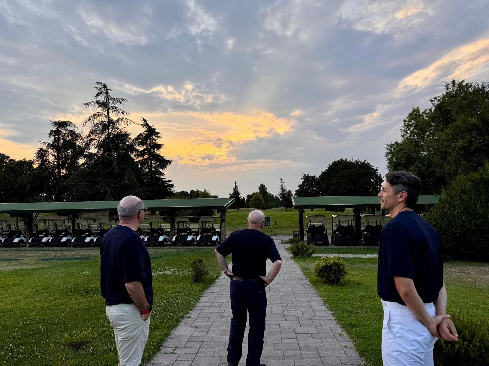 Il team di spalle, al golf, al tramonto